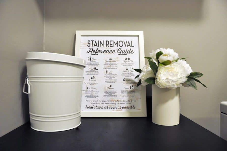 A framed stain removal reference guide printable sits on a shelf in our updated laundry room.