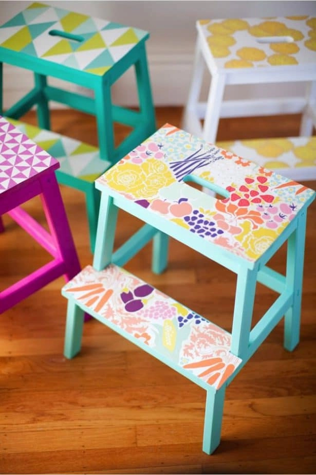 This kid-friendly IKEA hacks turns plain kids' step stools into fun, colorful pieces of furniture. Four small step stools are painted teal, pink, and white with colorful designs.