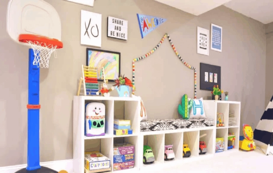 An IKEA Kallax storage shelf is turned into a toy storage and reading nook in a kid's playroom.