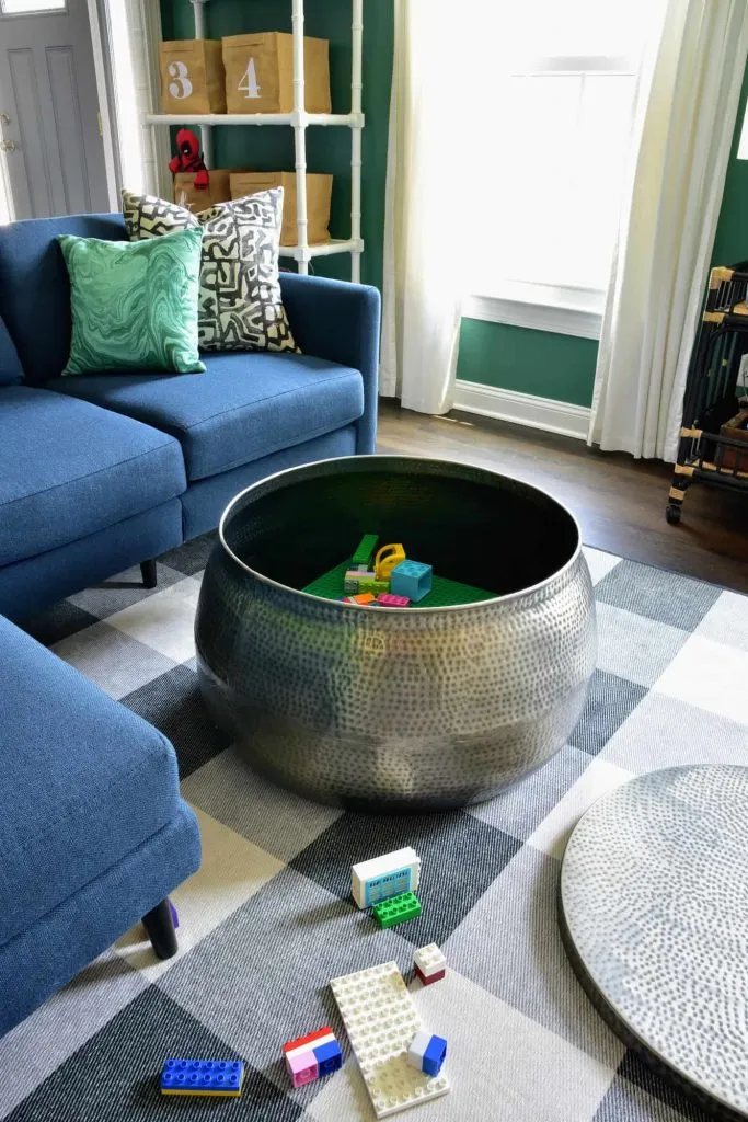 A large round coffee table doubles as LEGO storage for children's LEGO sets in the kids playroom.